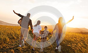 Happy family: mother, father, children son and daughter on sunset