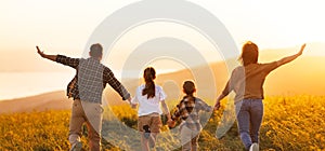 Happy family: mother, father, children son and daughter on sunset