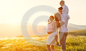 Happy family: mother, father, children son and daughter on sunset