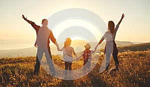 Happy family: mother, father, children son and daughter on sunset