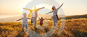 Happy family: mother, father, children son and daughter on sunset