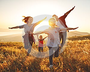 Happy family: mother, father, children son and daughter on sunset photo