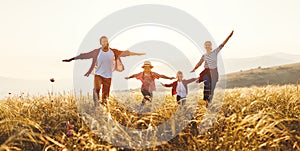 Happy family: mother, father, children son and daughter on sunset