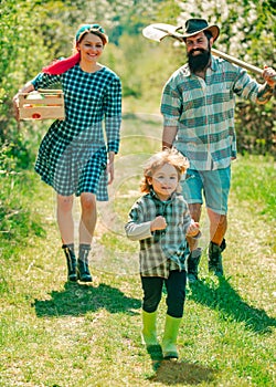 Happy family: mother, father, children son on spring garden background. Farming and agriculture cultivation. Wife and