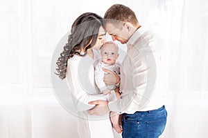 Happy family mother and father hold a newborn baby at home, the concept of happy loving family, lifestyle