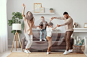 Happy family mother father and children dancing at home photo