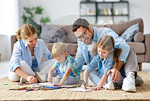 Happy family mother father and kids draw together at home