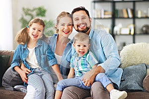 Happy family mother father and kids at home on couch