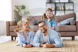 Happy family mother father and kids at home on couch