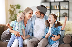 Happy family mother father and kids at home on couch