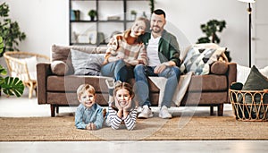 Happy family mother father and kids at home on couch