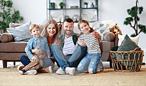 Happy family mother father and kids at home on couch