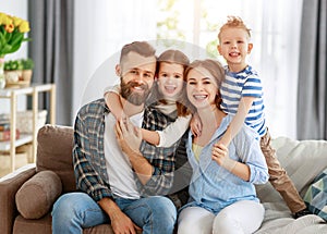 Happy family mother father and kids at home on couch