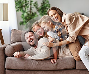 Happy family mother father and kids at home on couch