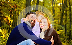 Happy family. Mother, father and little son together in park. Autumn nature. Smiling Autumn couple.