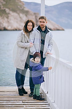 Happy family -mother, father and little son- walking in harbour