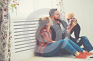 Happy family mother and father playing with a baby