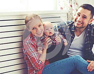 Happy family mother and father playing with a baby