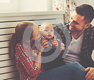 Happy family mother and father playing with a baby