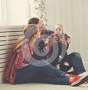 Happy family mother and father playing with a baby