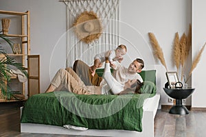 Happy family, mother and father playing with baby at home