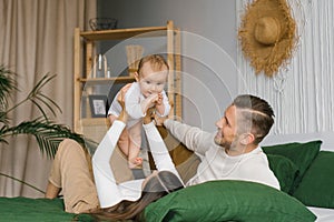 Happy family, mother and father playing with baby at home