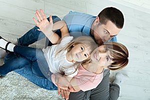 Happy family mother and father playing with baby at home. Unusually view from above.