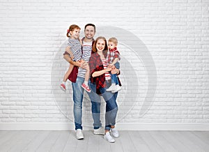 Happy family mother, father, son, daughter on a white blank wall