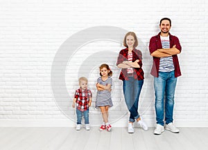 Happy family mother, father, son, daughter on a white blank wall