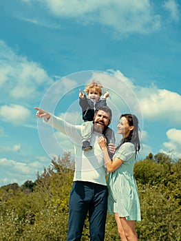 Happy family mother, father and son on sky background in summer. Cute boy with parents playing outdoor. Happy child