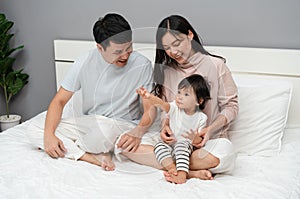 happy family, mother and father with toddler baby on bed