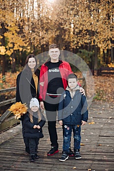 Happy family mother, father and two children posing together outdoors