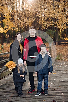 Happy family mother, father and two children posing together outdoors