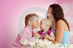 Happy family mother and her children boy and girl sitting indoor