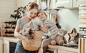 Happy family mother housewife and child   in laundry with washing machine