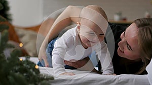 Happy family. Mother playing with her baby in the bedroom.