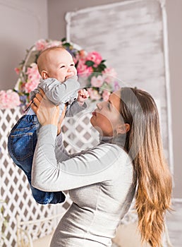 Happy family. mother playing with her baby in the room.