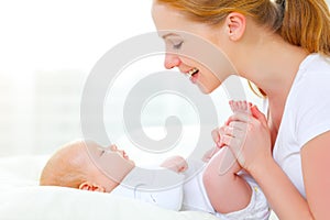 Happy family mother playing with newborn baby