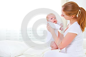 Happy family mother playing with newborn baby