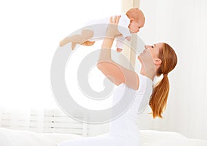 Happy family mother playing with newborn baby