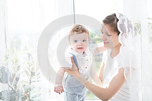 Happy family mother playing with newborn baby