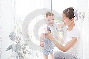 Happy family mother playing with newborn baby