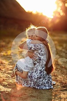 Happy family. Mother`s day concept. Mother playing with her little baby daughter girl on sunshine summer day