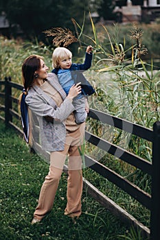 Happy family. Mother with son child playing having fun together on the grass in sunny summer day. Life moment