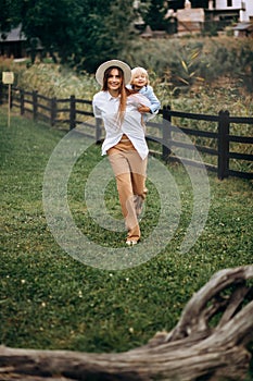 Happy family. Mother with son child playing having fun together on the grass in sunny summer day. Life moment