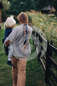 Happy family. Mother with son child playing having fun together on the grass in sunny summer day. Life moment