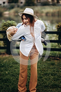 Happy family. Mother with son child playing having fun together on the grass in sunny summer day. Life moment