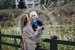 Happy family. Mother with son child playing having fun together on the grass in sunny summer day. Life moment