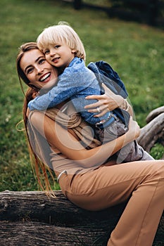 Happy family. Mother with son child playing having fun together on the grass in sunny summer day. Life moment