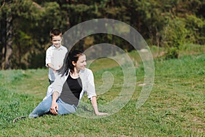 Happy family! Mother with son child playing having fun together on the grass in sunny summer day, life moment